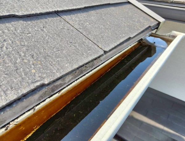 軒樋清掃前　泥が詰まって雨水が溢れる状態